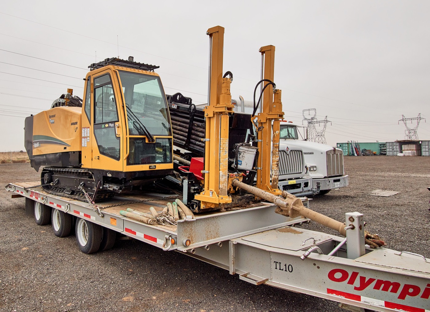 Directional boring rig loaded on a lowboy trailer at a job site